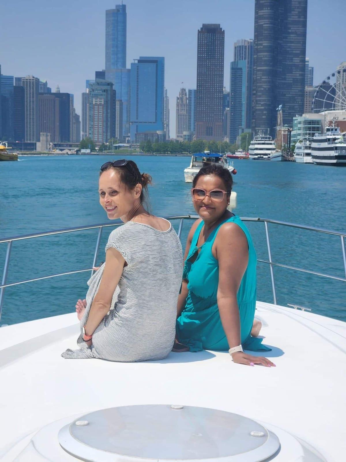 Two ISG teammates on a boat with the lake and skyline behind them